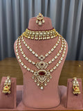 Ruby red kundan bridal set with choker, 3-line long haar, earrings and maang tikka on a mannequin