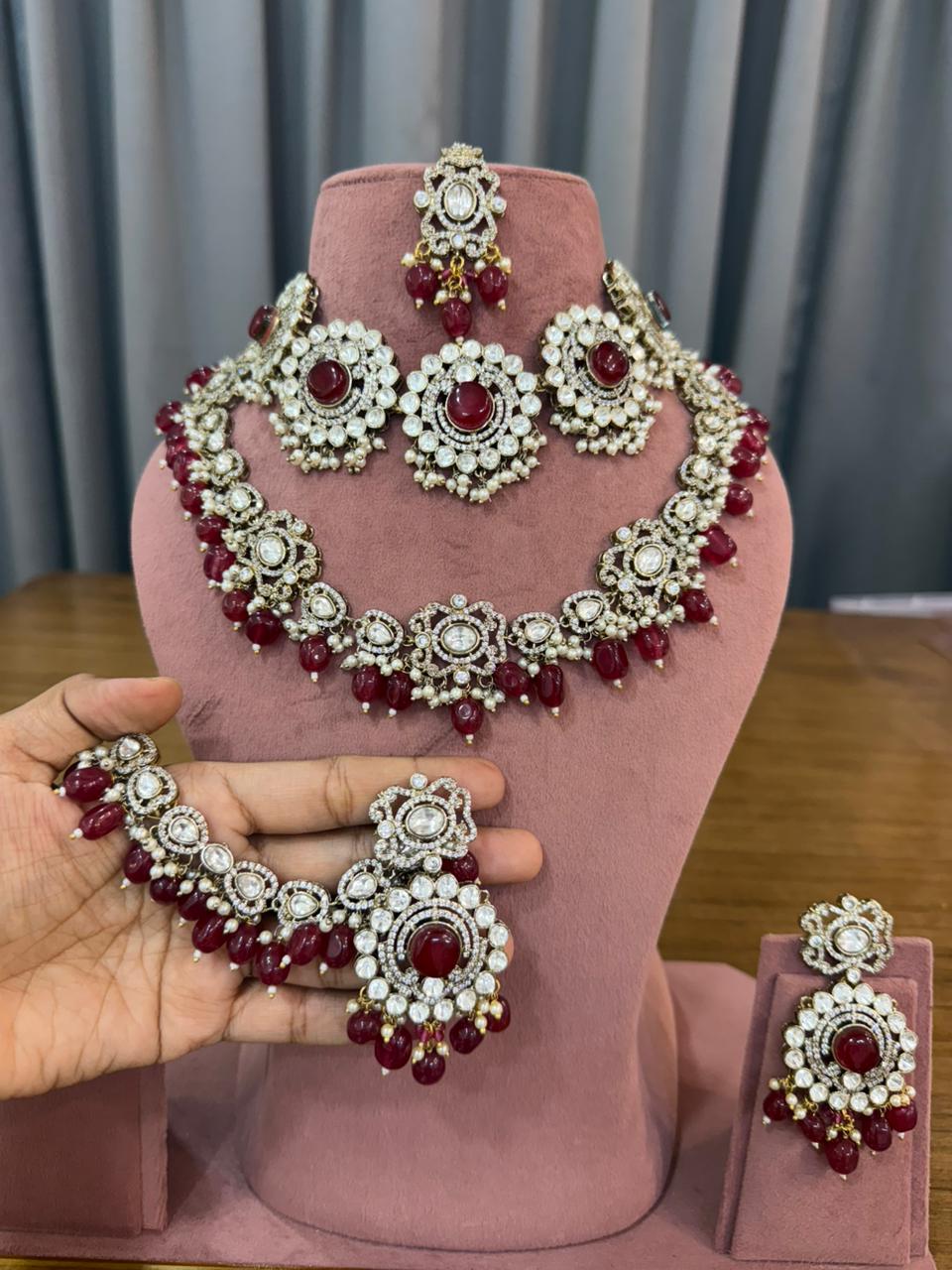 Maroon polki bridal jewellery set close-up showing oval cabochon stones, pearl drops and antique gold-tone setting - handcrafted Kundan choker for Indian brides