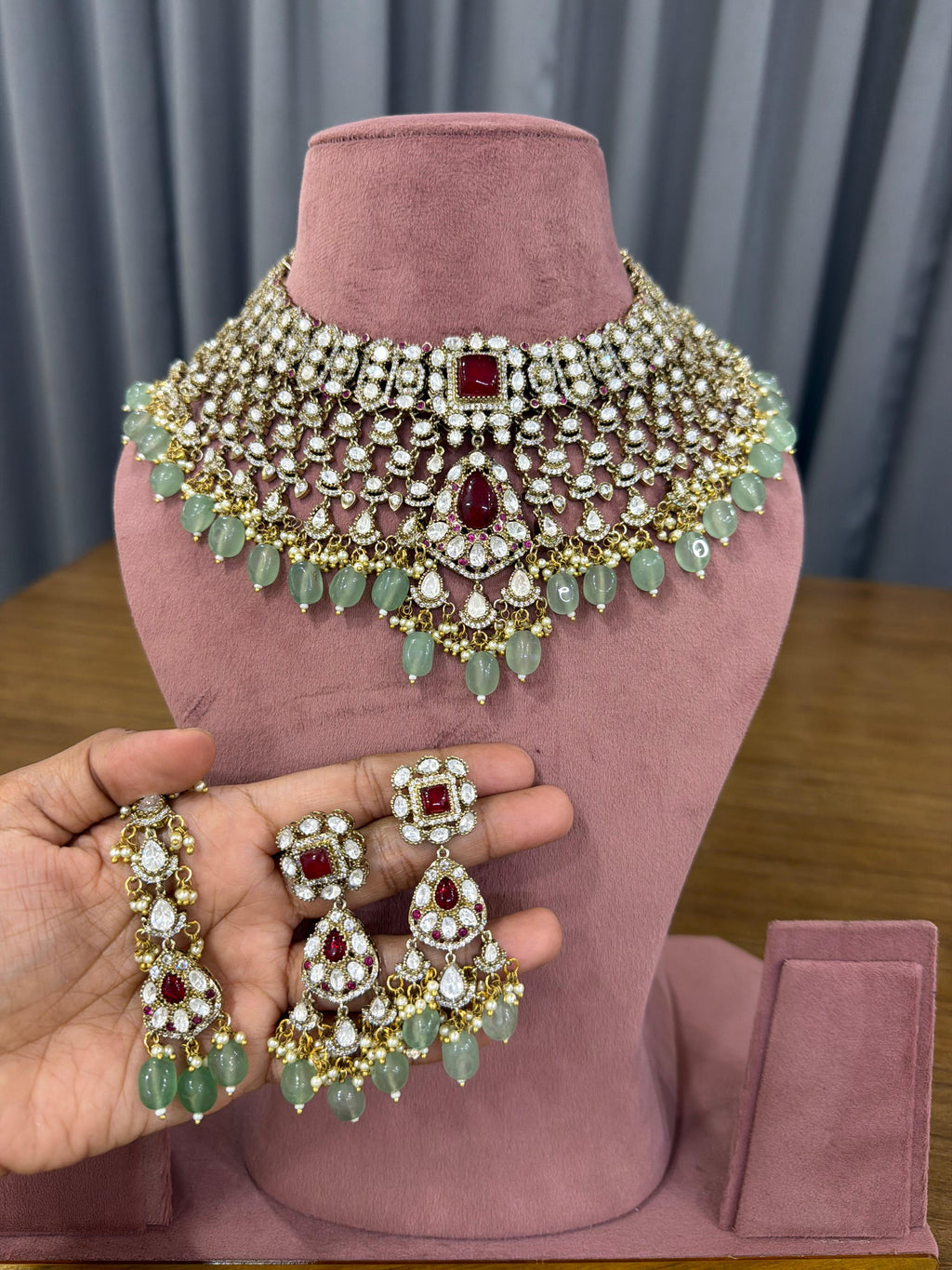 Ganesh Kundan and Polki bridal choker set with ruby red stones and mint green beads for Indian brides.