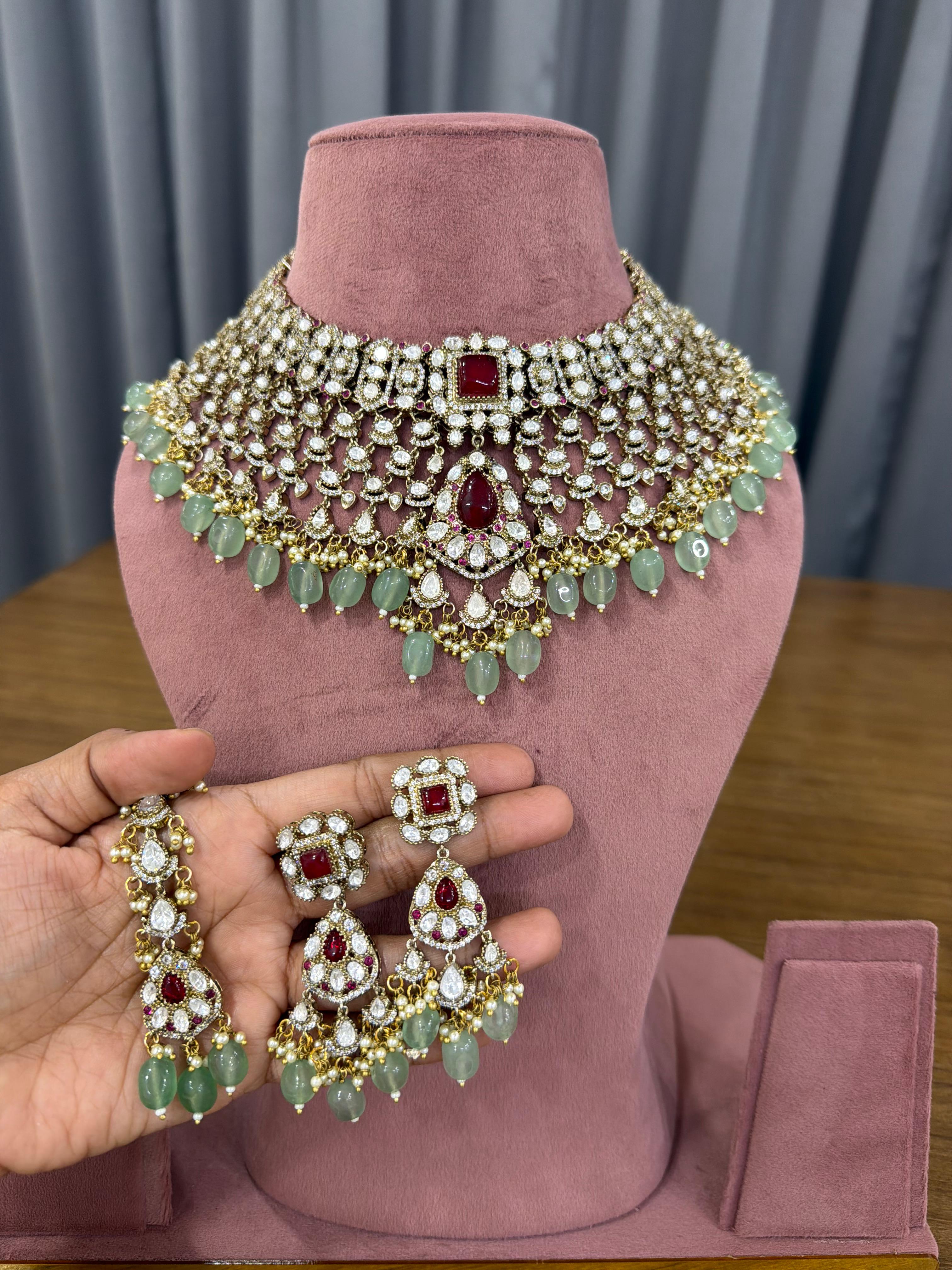 Ganesh Kundan and Polki bridal choker set with ruby red stones and mint green beads for Indian brides.